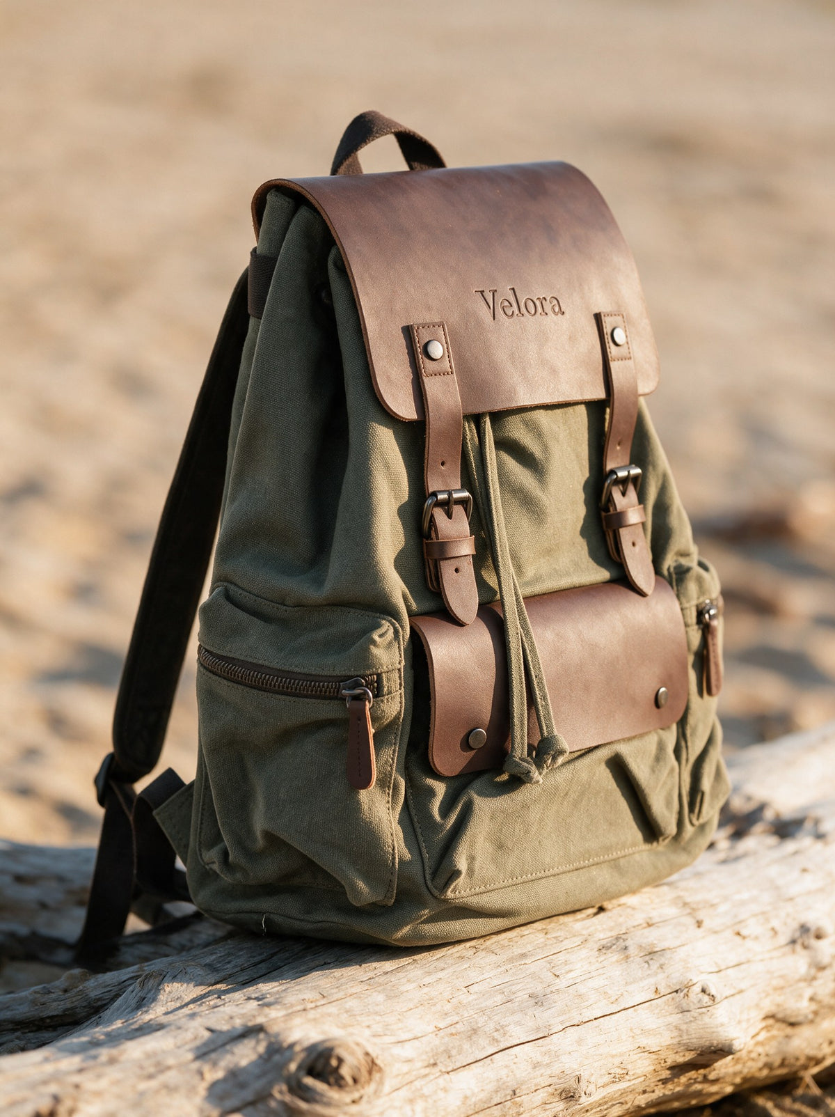 Vintage Canvas Rucksack schräg von der Seite auf einem Treibholzstamm, olivgrünes Canvas mit Kunstleder-Klappe und seitlicher Reißverschlusstasche