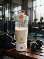 VELORA Volt mit fertig gemixtem Protein-Shake auf einer Holzbank im Gym neben Kurzhanteln und Sporttasche