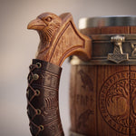 Henkel-Detail des Wikinger Bierkrugs: geschnitzter Rabenkopf, Griffstück in Leder-Optik mit geprägtem Drakkar-Langschiff und Mjölnir-Relief